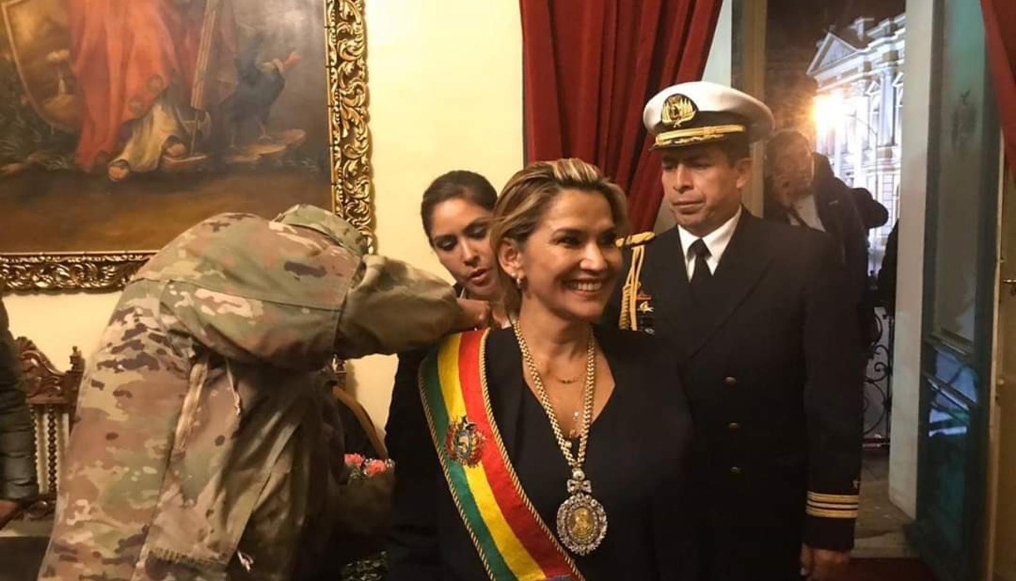 Un militar coloca la banda presidencial a la flamante presidenta de Bolivia, Jeanine Áñez, designada sin la participación de la Asamblea Legislativa, en donde el MAS tiene mayoría absoluta..